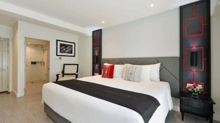 Ein Hotelzimmer mit einem großen Bett und einem Stuhl