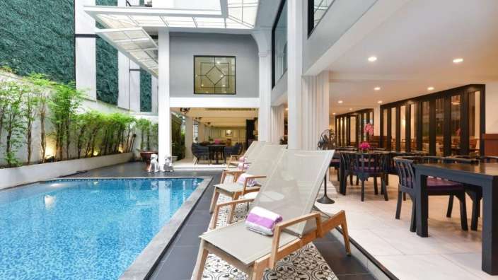 Ein Hotel mit einem Swimmingpool und einem Tisch und Stühlen