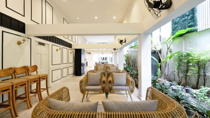 Ein Wohnzimmer mit Rattanmöbeln und Stühlen