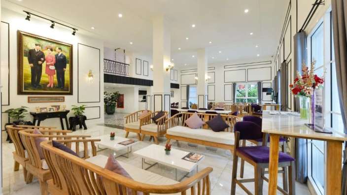 Ein Wohnzimmer mit vielen Möbeln und einem Gemälde an der Wand