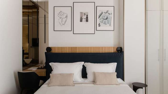 Ein Schlafzimmer mit einem Bett und drei Bildern an der Wand