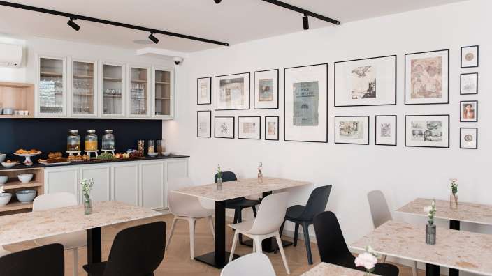 Ein Esszimmer mit Tischen und Stühlen und Bildern an der Wand