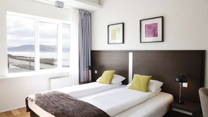 Ein Hotelzimmer mit zwei Betten und einem großen Fenster