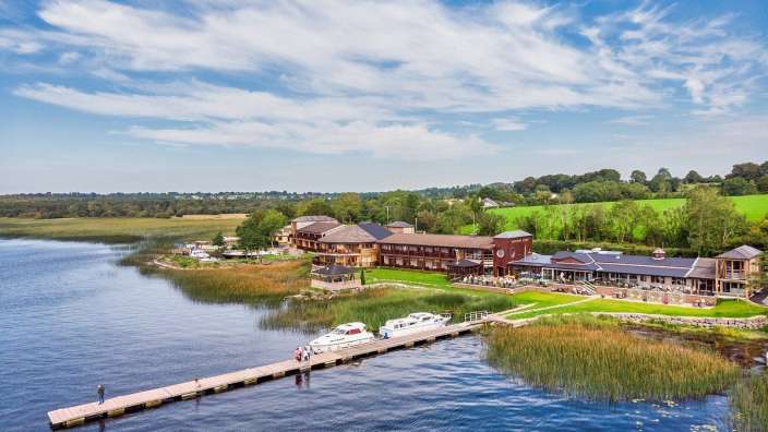 Eine Gruppe von Menschen steht an einem Dock neben einem See
