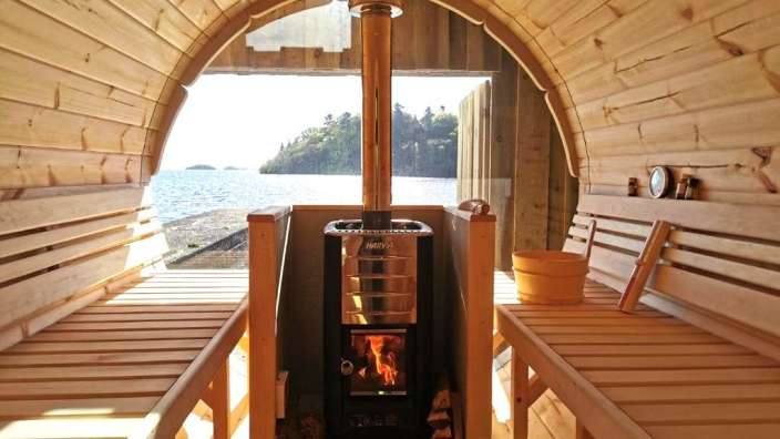 Eine Holzsauna mit einem harvia-Kamin darauf