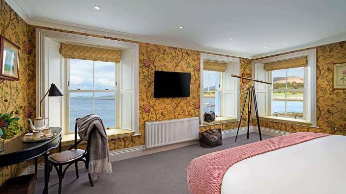 Ein Schlafzimmer mit einem Bett, einem Schreibtisch und einem Fernseher