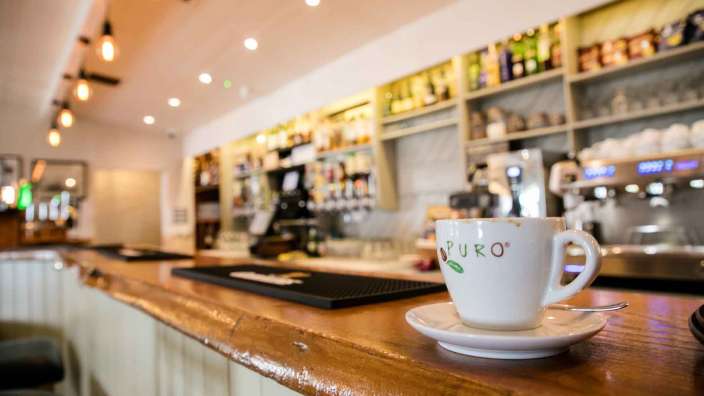Eine weiße puro-Tasse sitzt auf einer Bar
