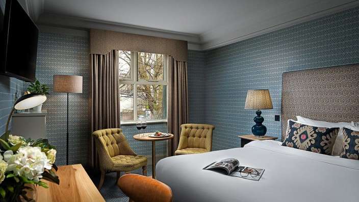 Ein Hotelzimmer mit einem Bett und zwei Stühlen