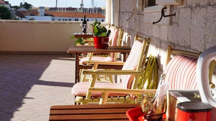 Eine Reihe von Stühlen und Tischen auf einem Balkon