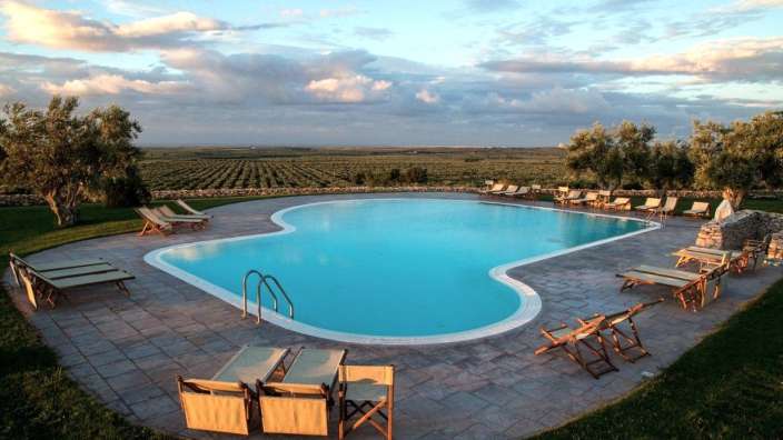 Ein großer Pool mit Liegestühlen und Stühlen um ihn herum