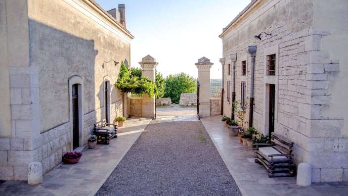 Eine Gasse zwischen zwei alten Gebäuden mit einer Bank in der Mitte