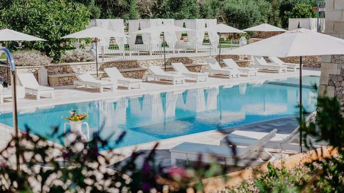 Liegestühle und Sonnenschirme um einen großen Swimmingpool