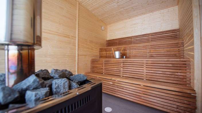 Eine Holzsauna mit einem Eimer auf einem Regal