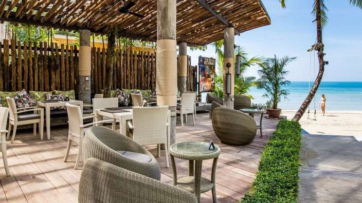 Ein Restaurant mit Tisch und Stühlen auf einem Holzdeck