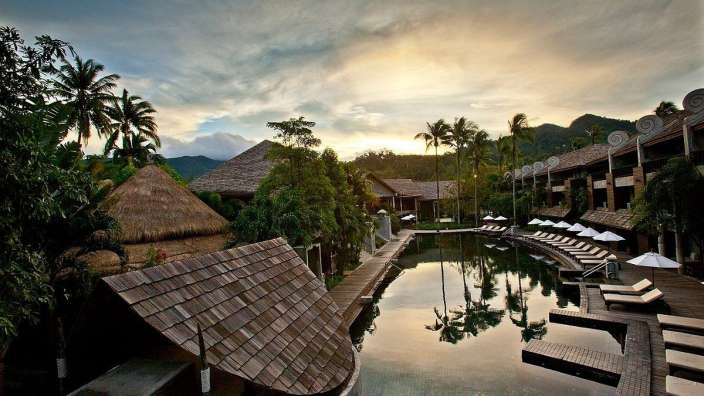Ein Hotel mit einem großen Pool und vielen Sonnenschirmen