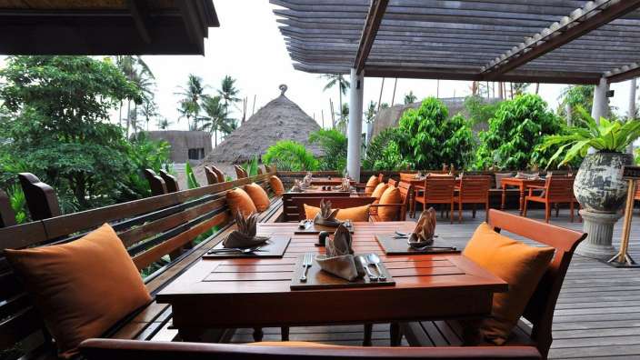 Ein Restaurant mit Holztischen und Stühlen auf einem Deck