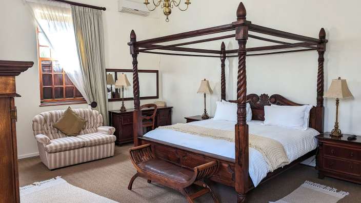 Ein Schlafzimmer mit einem Himmelbett und einem Stuhl