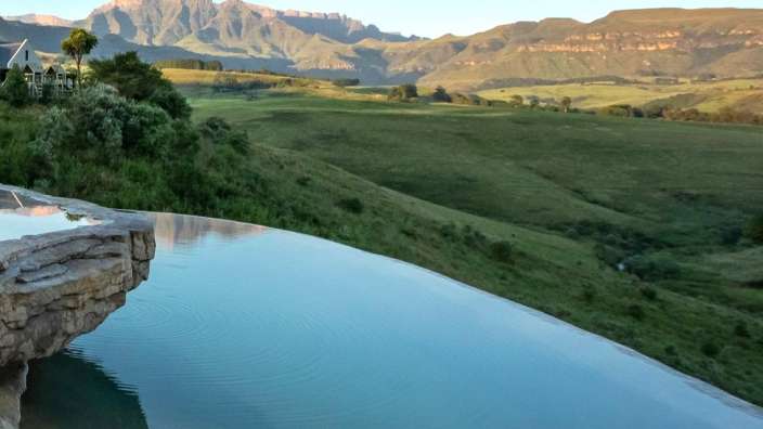 Ein Infinity-Pool mit einem Berg im Hintergrund