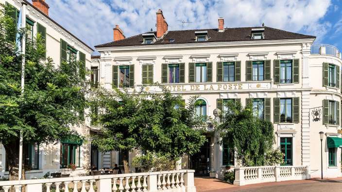 Ein großes weißes Gebäude mit dem Namen Hotel de la poste darauf