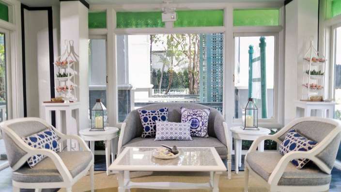 Ein Wohnzimmer mit weißen Möbeln und blau-weißen Kissen