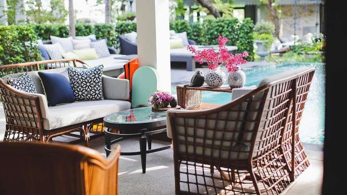 Ein Wohnzimmer mit einer Couch und Stühlen neben einem Swimmingpool