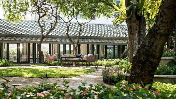 Ein Garten mit einem Tisch und Stühlen im Vordergrund