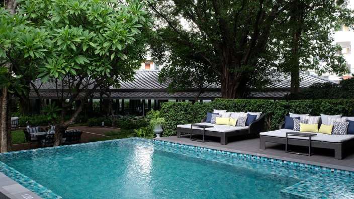 Ein Swimmingpool mit Liegestühlen und Stühlen umgeben