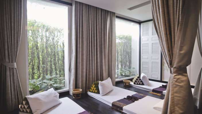 Ein Raum mit zwei Betten und vielen Fenstern