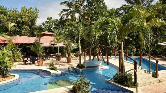 Ein großer Swimmingpool in einem tropischen Garten