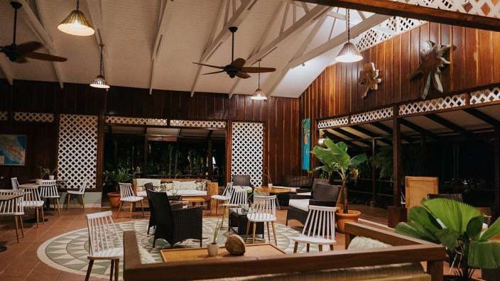 Ein Wohnzimmer mit vielen Stühlen und Deckenventilatoren