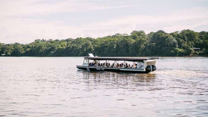 Ein kleines weißes Boot fährt auf einem See