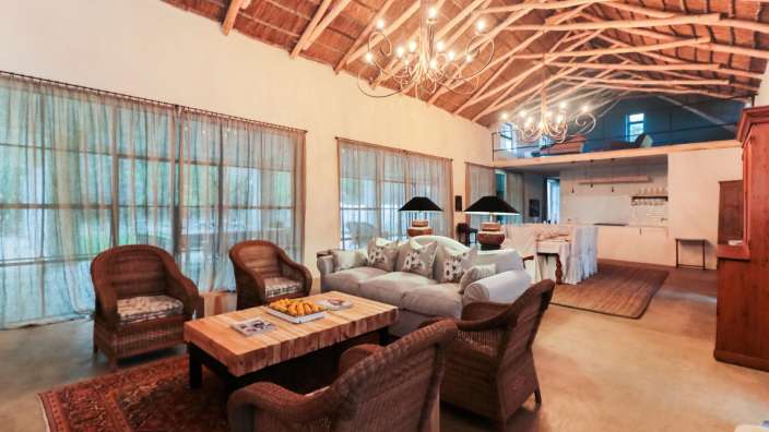 Ein Wohnzimmer mit vielen Möbeln und einem Strohdach