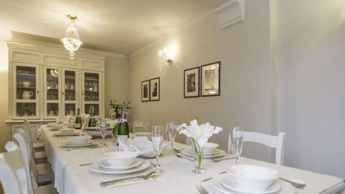 Ein langer Tisch mit weißen Tellern und Gläsern