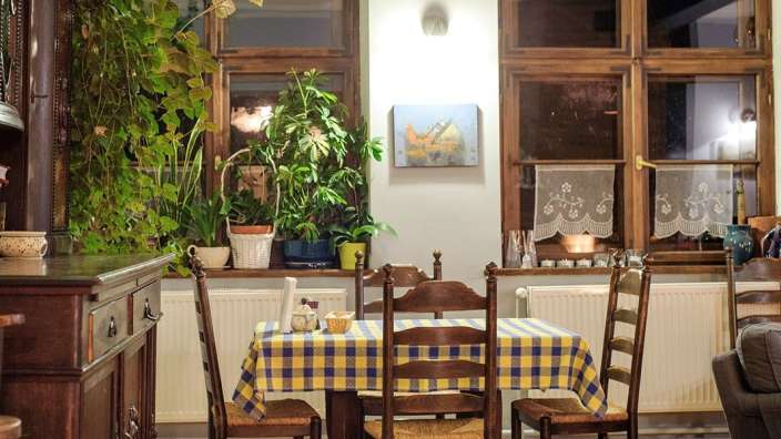 Ein Esszimmer mit einem Tisch und Stühlen und einem Gemälde an der Wand