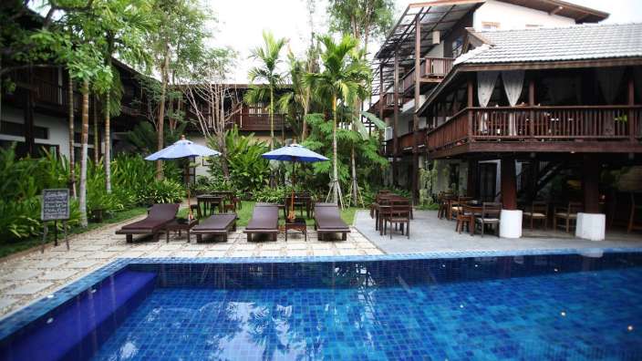 Ein großer Swimmingpool mit Liegestühlen und Sonnenschirmen davor