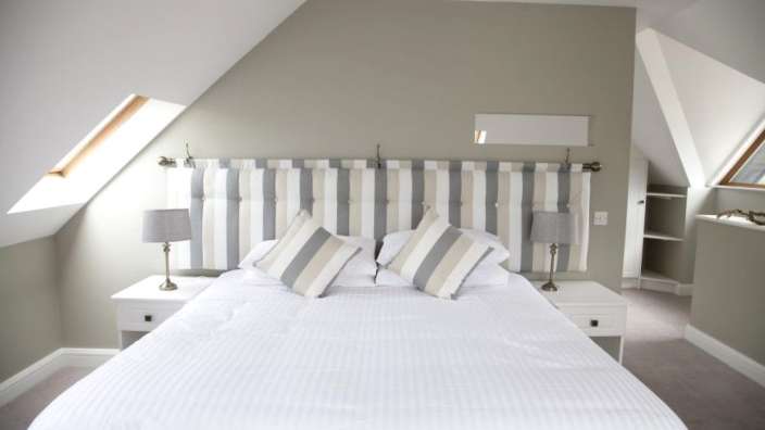 Ein Schlafzimmer mit einem Bett und einem gestreiften Kopfteil