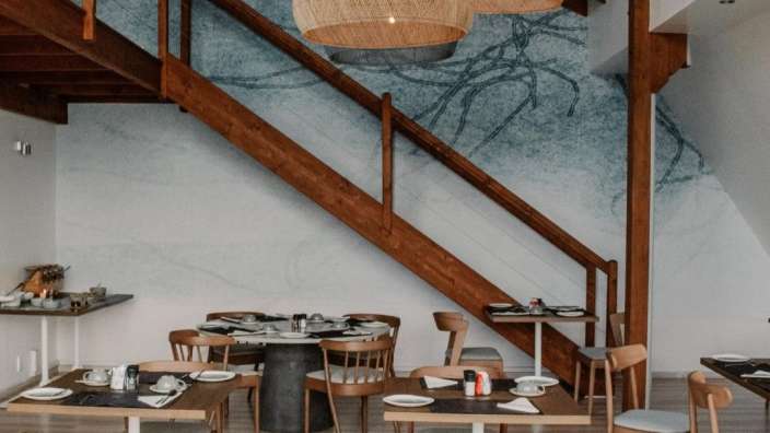 Ein Esszimmer mit Holztreppen und Tischen und Stühlen