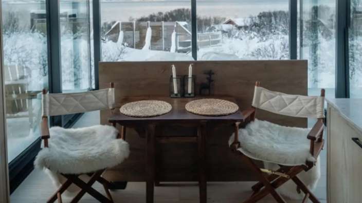 Ein Tisch und Stühle in einem Raum mit Blick auf den Schnee