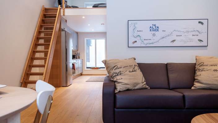 Ein Wohnzimmer mit einem braunen Ledersofa und einer Karte des alta-Reviers an der Wand