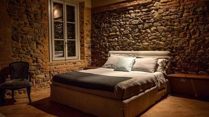 Ein Schlafzimmer mit einem Bett und einer Steinmauer