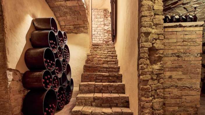 Eine Treppe führt in einen Keller mit einem Weinregal
