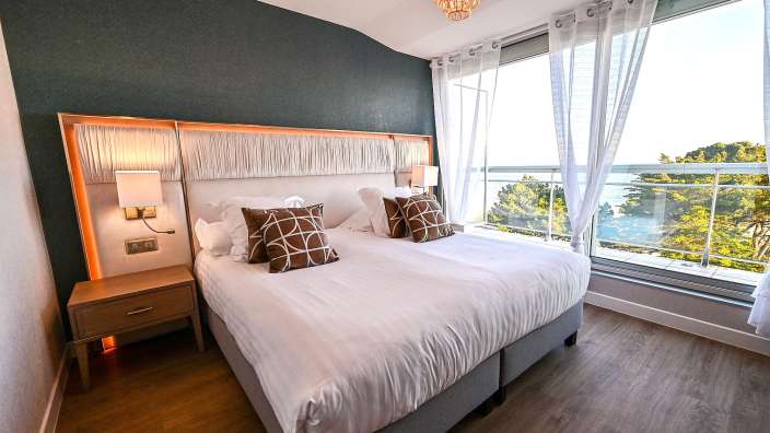 Ein Hotelzimmer mit einem großen Bett und einem großen Fenster