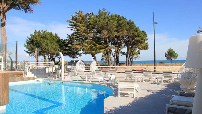 Ein großer Swimmingpool mit weißen Stühlen und Stühlen umgeben