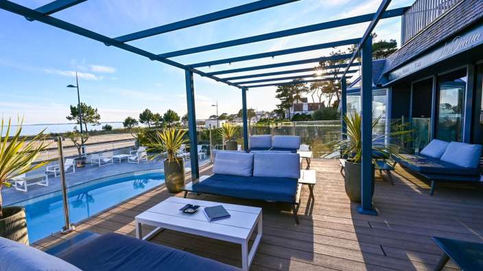 Ein Wohnzimmer mit einer Couch und einem Tisch neben einem Swimmingpool