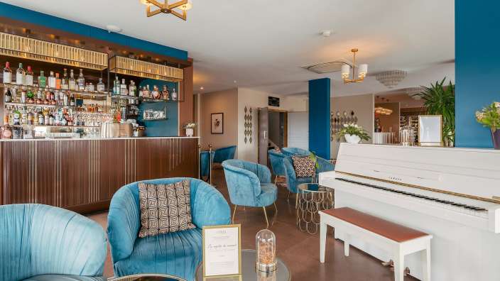 Ein Wohnzimmer mit blauen Stühlen und einem weißen klavier