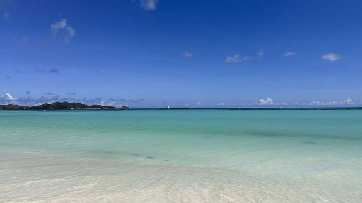 Ein Strand mit weißem Sand und türkisfarbenem Wasser