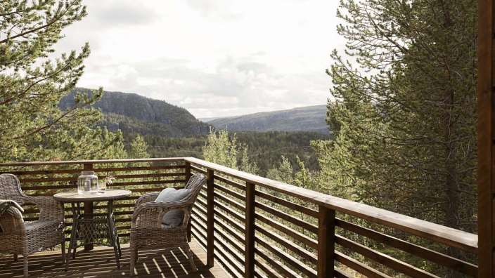 Ein Tisch und Stühle auf einem Balkon mit Blick auf die Berge