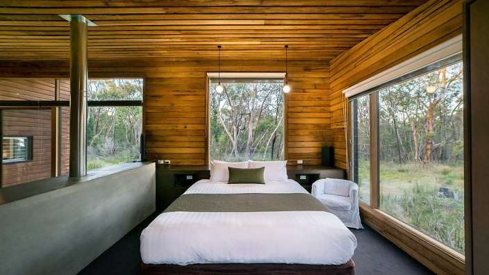 Ein Schlafzimmer mit einem Bett und vielen Fenstern