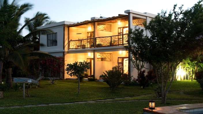 Ein großes weißes Haus mit vielen Fenstern und Balkonen