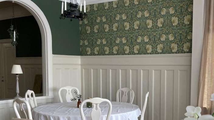 Ein Esszimmer mit einem weißen Tisch und weißen Stühlen